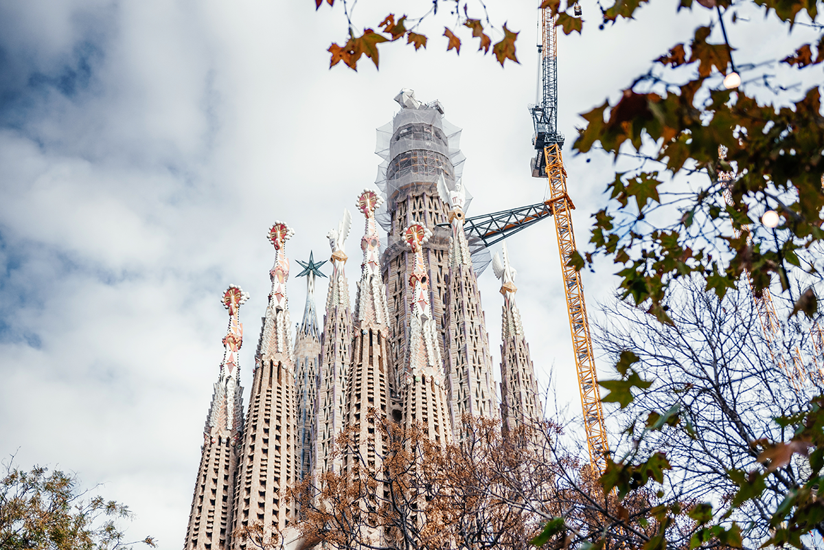 Barcelona Sagrada Familia spires and central construction tower viewed from the park
